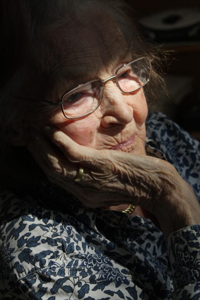 An elderly woman ponders how she is going to pay her monthly health insurance premium