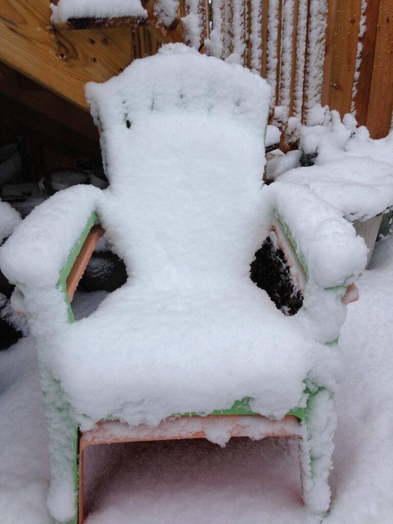 Adirondack chair covered in snow